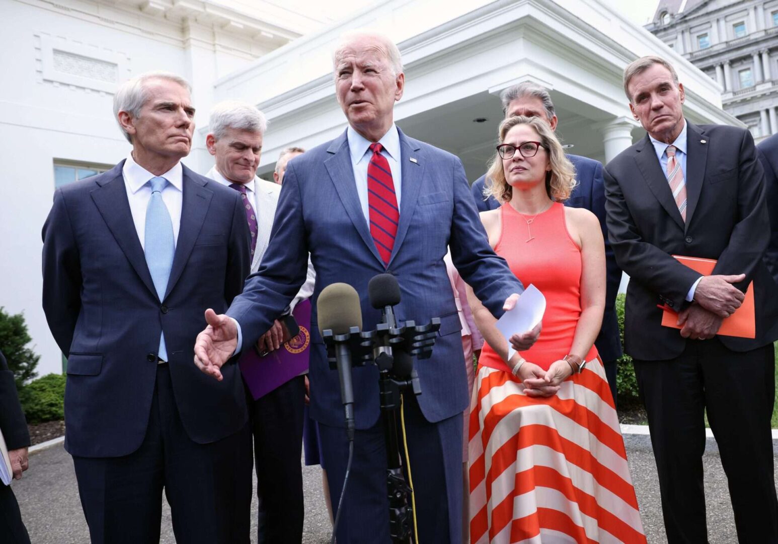 President Joe Biden (C), joined by from left to right, Sen. Rob Portman (R-OH), Sen. Bill Cassidy (R-LA), Sen. Kyrsten Sinema (D-AZ) and Sen. Mark Warner (D-VA), speaks after the bipartisan group of Senators reached a deal on an infrastructure package at the White House.