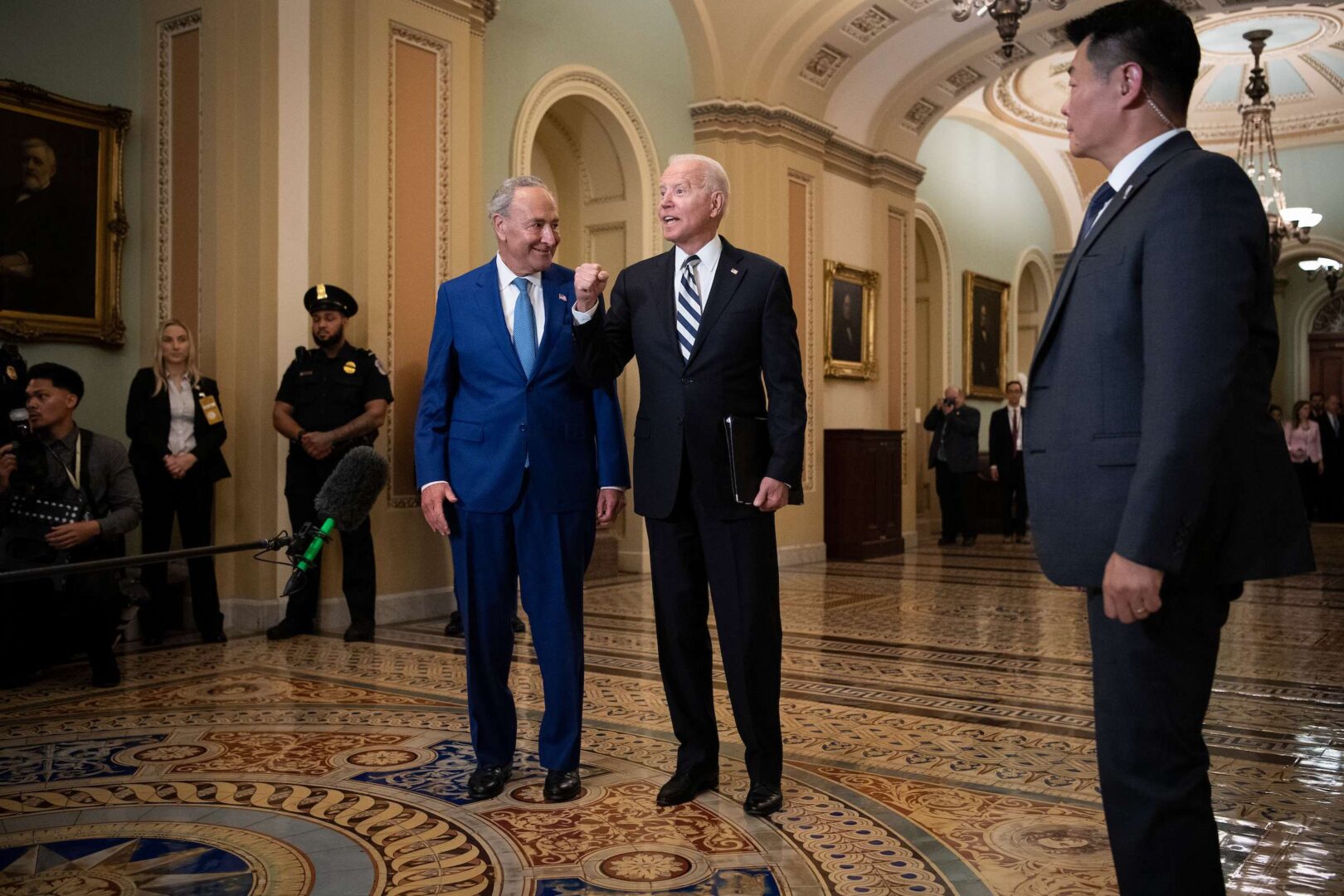 President Joe Biden walks with Senate Majority Leader Chuck Schumer as he arrives at the Capitol on Wednesday to pitch a $3.5 trillion budget agreement to Senate Democrats over lunch. 