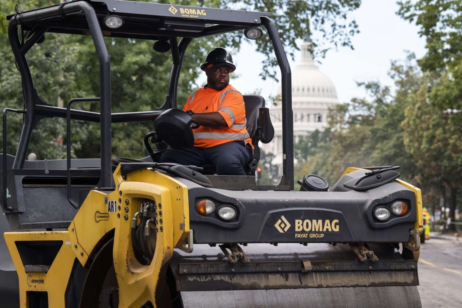 A worker uses an asphalt roller to pave Maryland Avenue Northeast in Capitol Hill on Oct. 4, 2021.