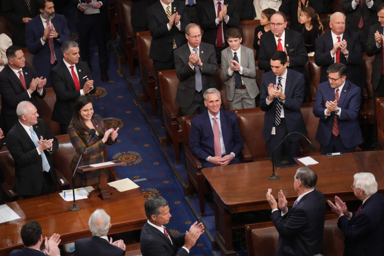 House Republican leader Kevin McCarthy sits as colleagues stand around him applauding after he was nominated for speaker in the 118th Congress.