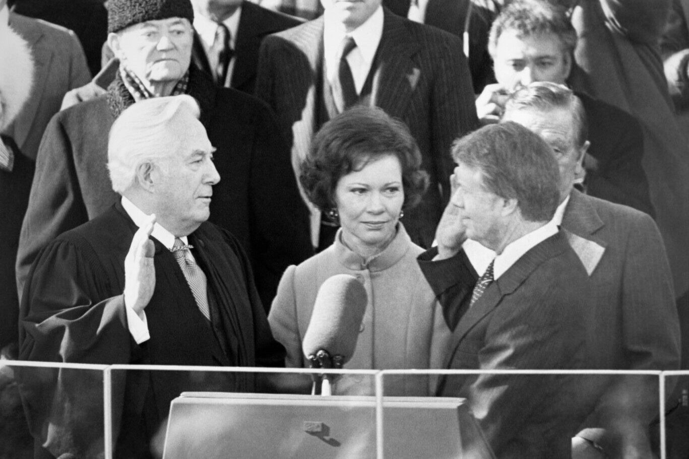 Rosalynn Carter, center, watches as husband Jimmy Carter recites the presidential oath of office administered by Chief Justice Warren Burger, left, on Jan. 20, 1977.
