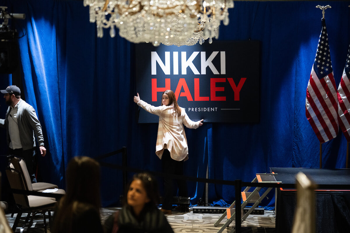 An aide takes down a sign after a rally by Republican presidential candidate Nikki Haley during the District of Columbia's Republican presidential primary at the Madison Hotel in Washington, D.C., on March 1. Haley won the D.C. primary, but ultimately fell short and suspended her campaign on Wednesday. Where her supporters go will be a key question in the general election, David Winston writes. 
