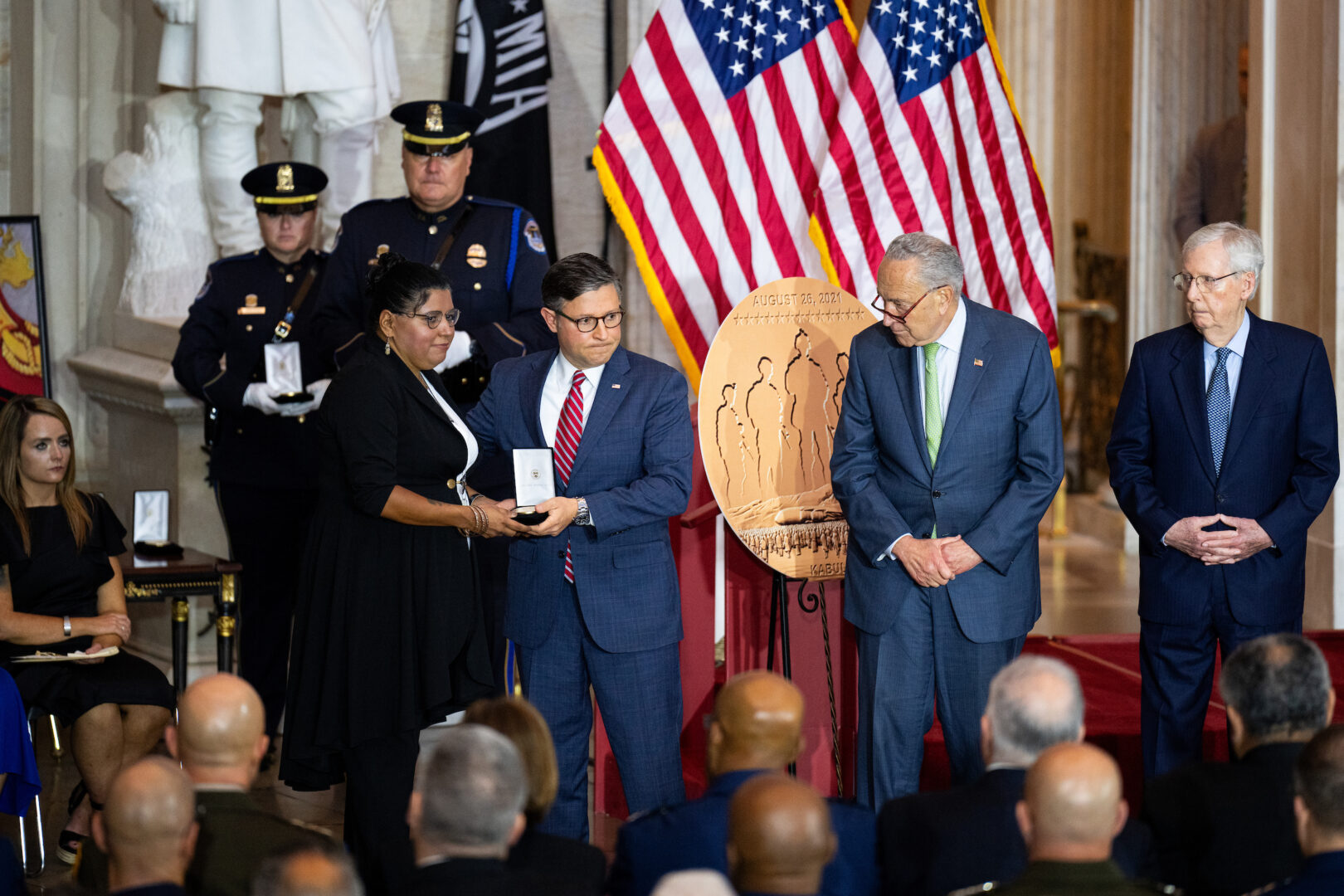 House Speaker Mike Johnson, Senate Majority Leader Charles E. Schumer and Senate Minority Leader Mitch McConnell hand medals to family members of the servicemembers killed in the 2021 terrorist attack at the airport in Kabul, Afghanistan, during a Congressional Gold Medal ceremony in the Capitol Rotunda on Tuesday.