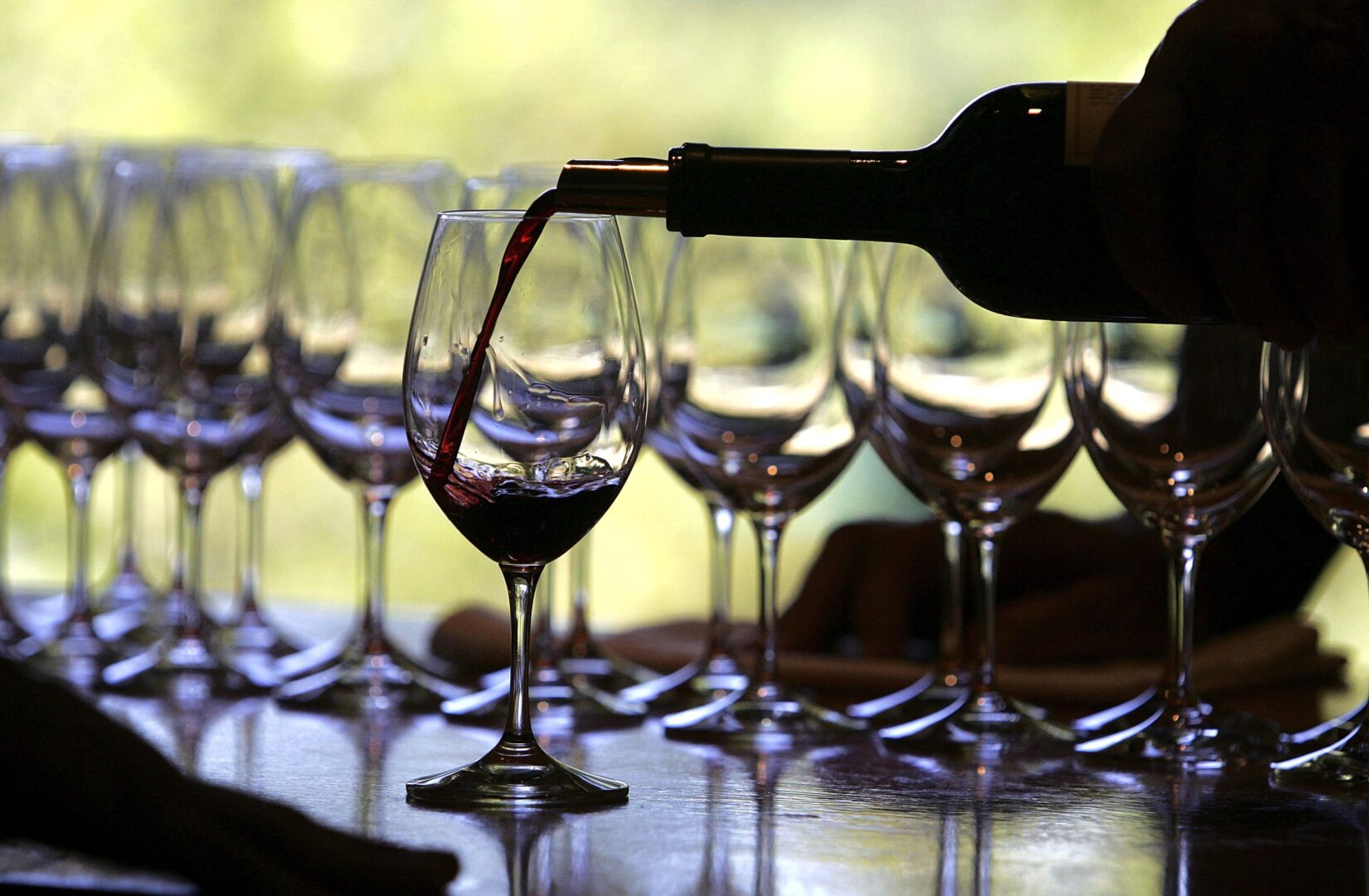 A worker at St. Supery winery in Rutherford, Calif., pours a glass of wine for a tasting. Since the Dietary Guidelines for Americans were last updated in 2020, more research has emerged suggesting that even drinking moderately could be associated with health issues.
