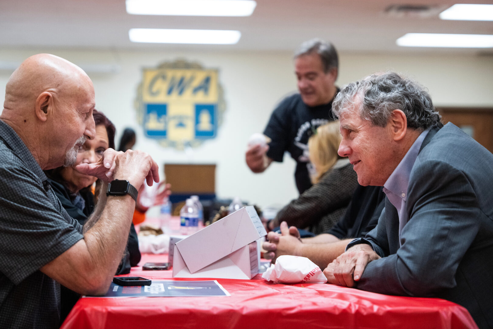 Sen. Sherrod Brown, D-Ohio, right, talks with guests during a campaign rally at the Communications Workers of America Local 4370 in Brooklyn Heights, Ohio, on Saturday, Oct. 26, 2024. Brown is running for reelection against Republican candidate Bernie Moreno. 