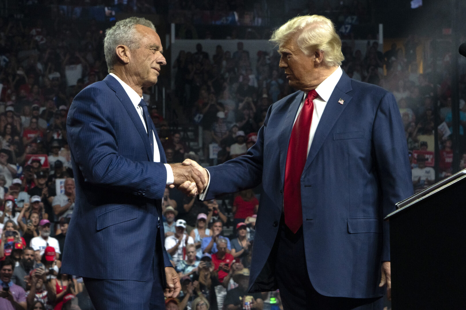 Robert F. Kennedy Jr. and Donald Trump shake hands at a campaign rally in Glendale, Ariz., on Aug. 23.