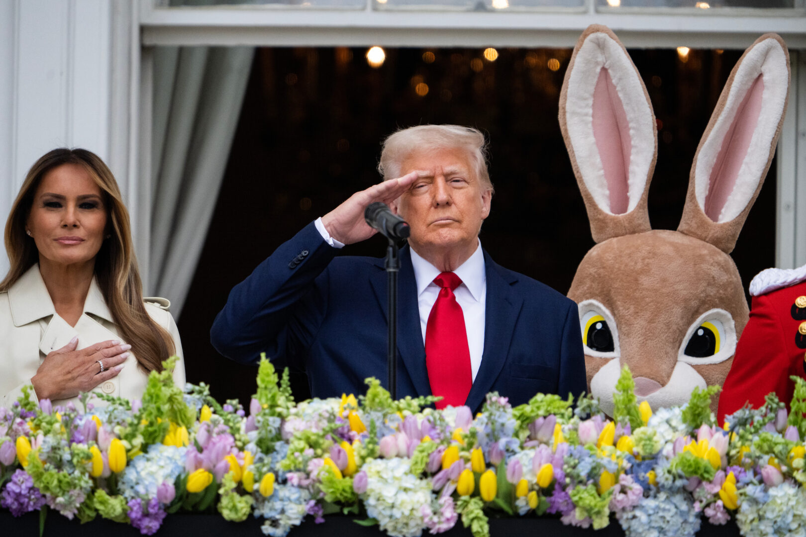 President Donald Trump and first lady Melania Trump listen to Master Gunnery Sgt. Kevin Bennear of the U.S. Marine Band sing the national anthem during the White House Easter Egg Roll on April 21.