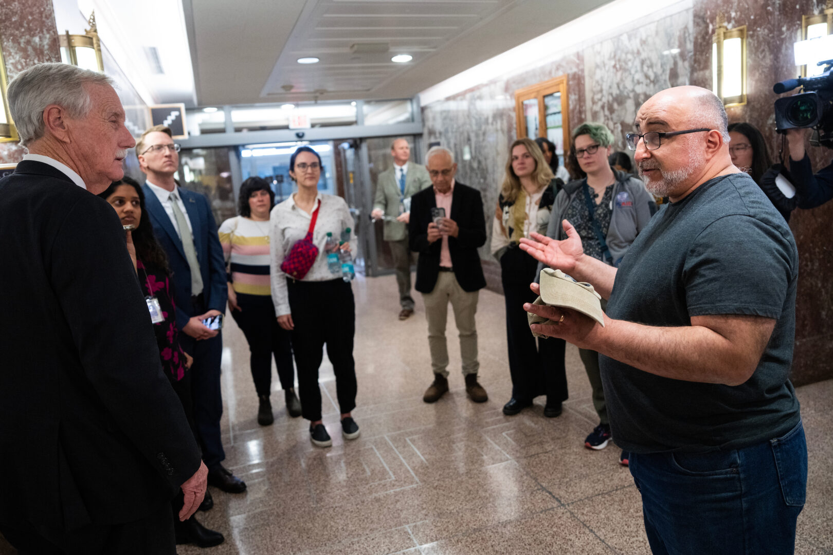 Matt Cutler, right, a former Health and Human Services employee who was fired on Tuesday, talks with Maine independent Sen. Angus King, left, inside the Dirksen Senate Office Building on Tuesday.