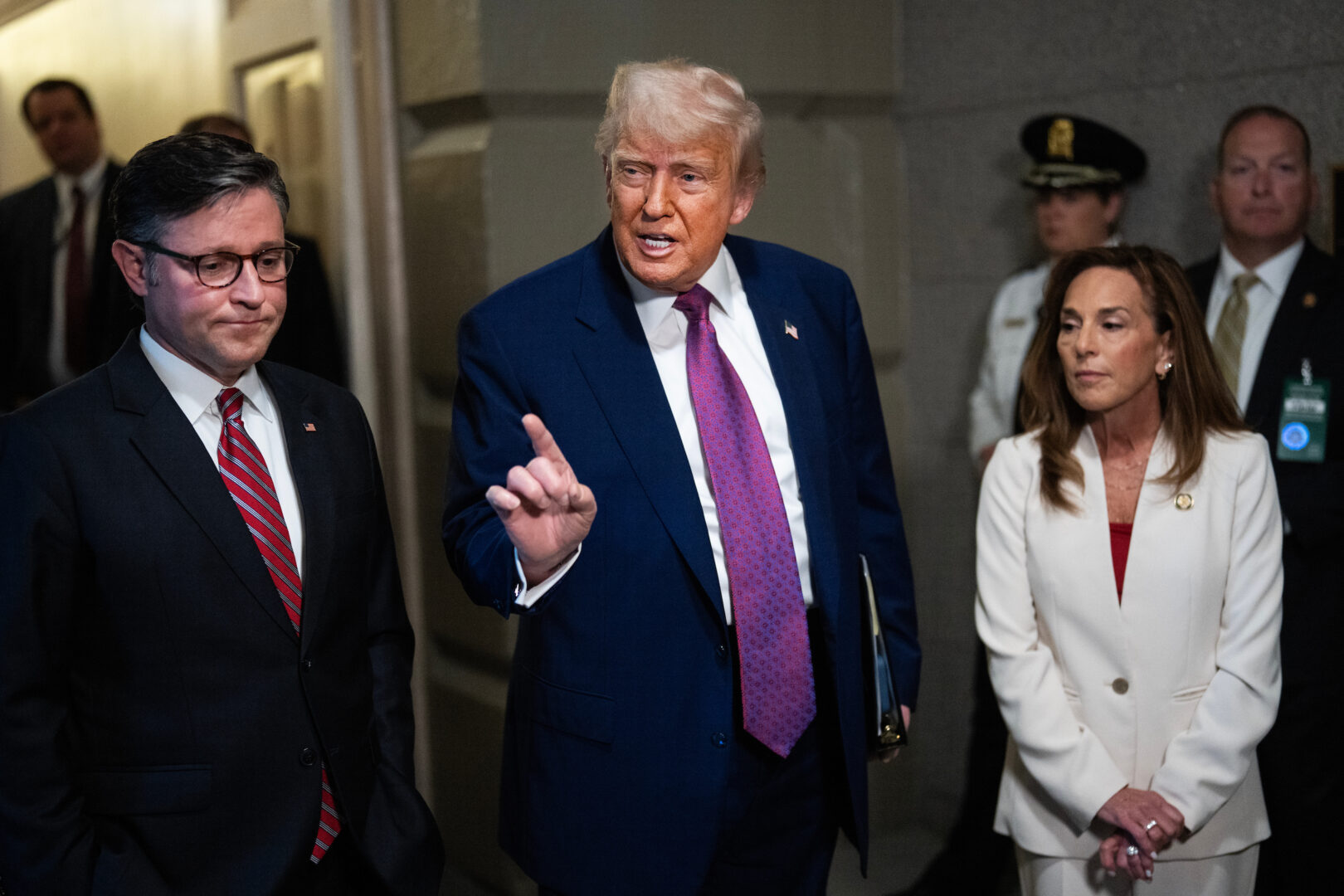 President Donald Trump, Speaker Mike Johnson, R-La., and House Republican Conference Chair Lisa McClain, R-Mich., talk with reporters before a House Republican Conference meeting on the budget reconciliation bill in the Capitol on Tuesday. 