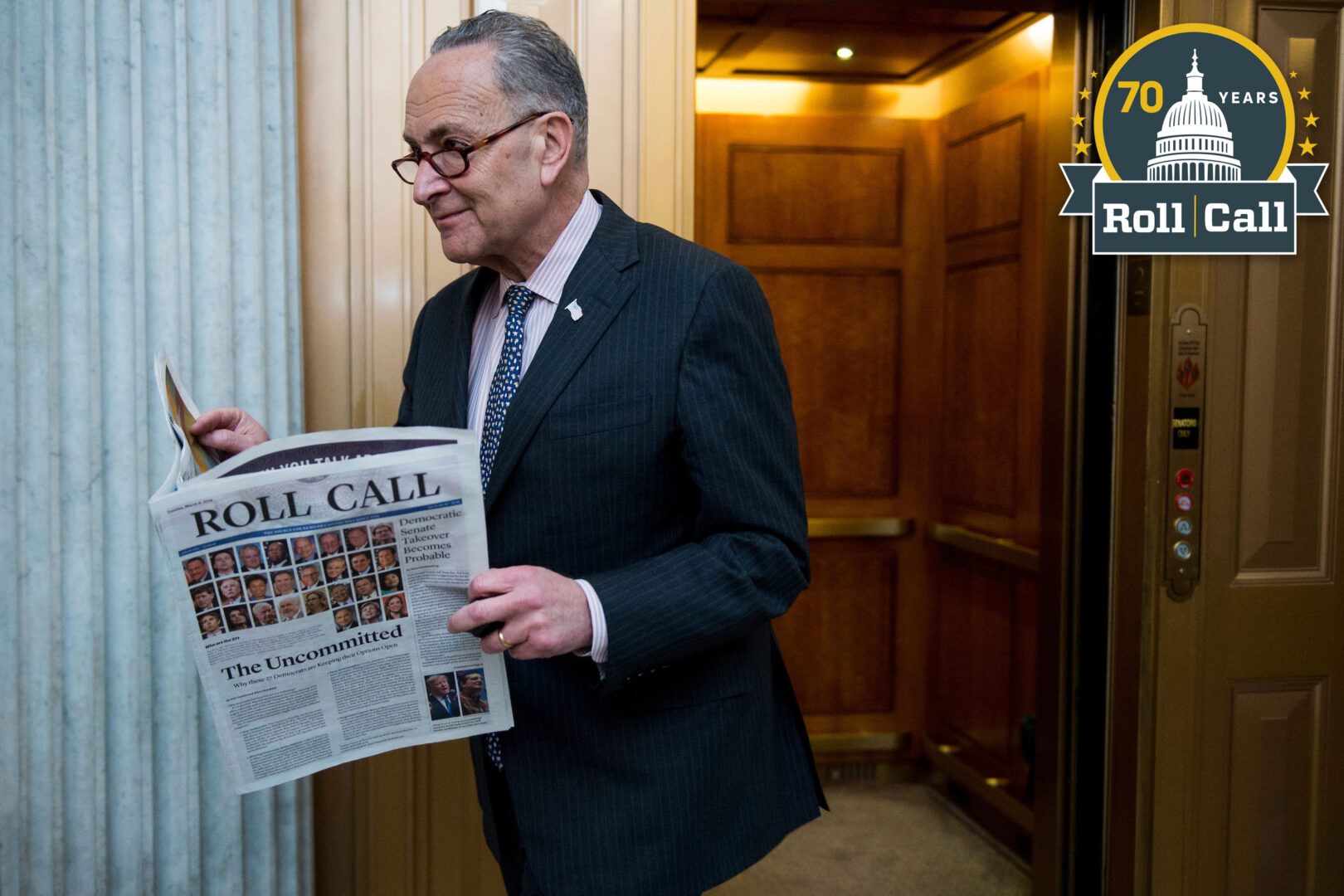 New York Sen. Charles E. Schumer reads Roll Call on March 12, 2016, as he arrives for a policy luncheon in the Capitol.