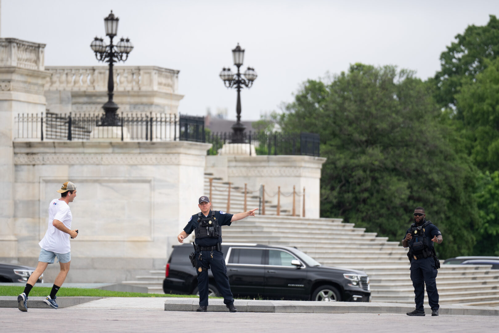 Capitol Police officers direct a jogger away from the Senate Plaza on Tuesday. The department has placed the plaza in restricted mode as a security measure.
