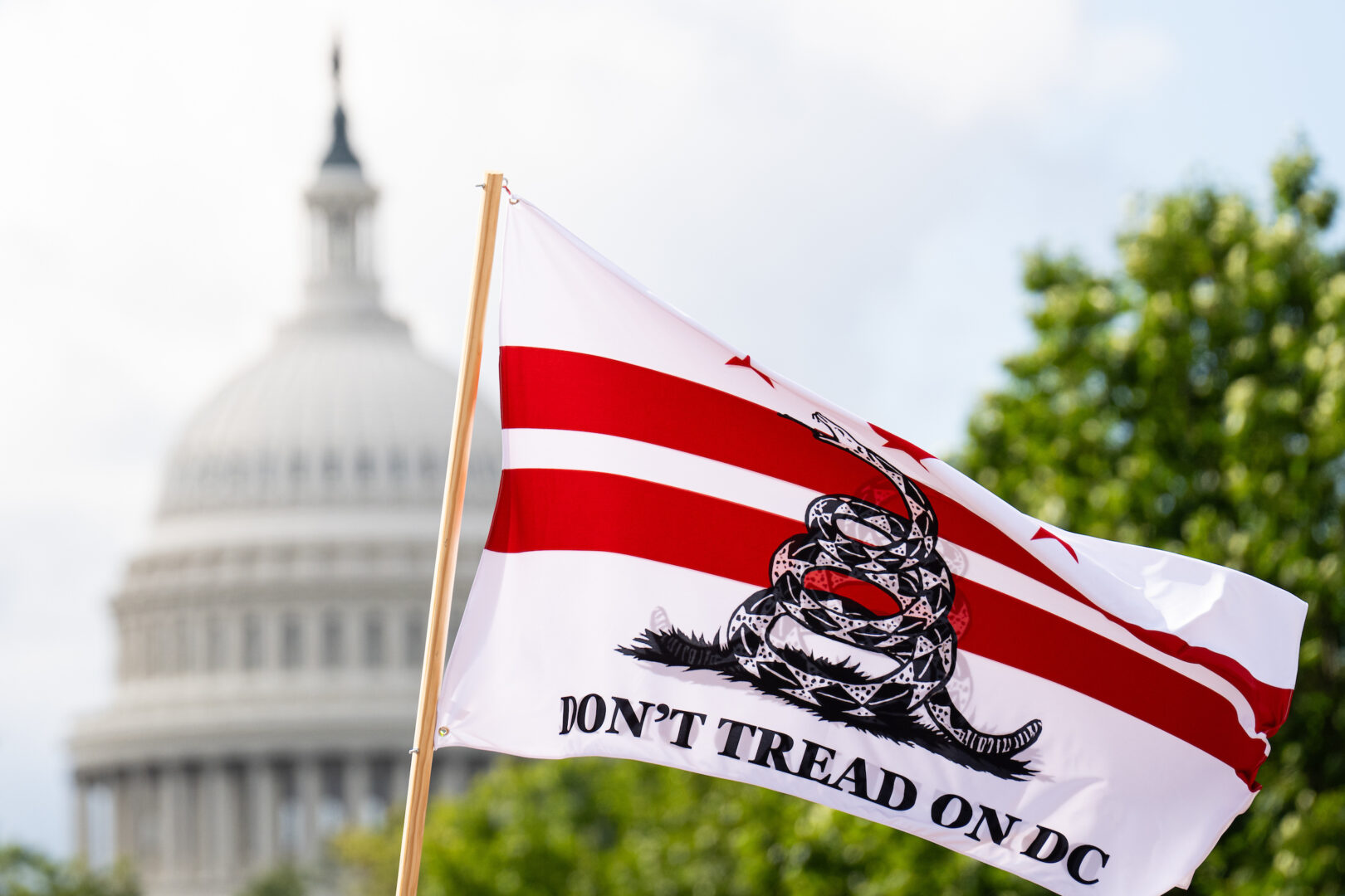 An activist waves a “Don’t Tread On DC” flag outside Union Station on Sept. 2. The House passed a pair of bills on Tuesday that would override local laws on youth sentencing, part of a push to exert more control over D.C. that has angered advocates.