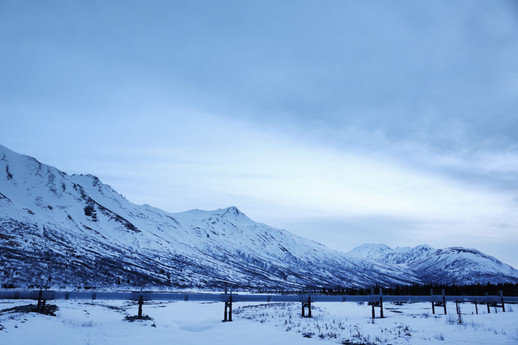 A part of the Trans-Alaska Pipeline System runs past the Alaska Range mountains on May 5, 2023, near Delta Junction, Alaska.