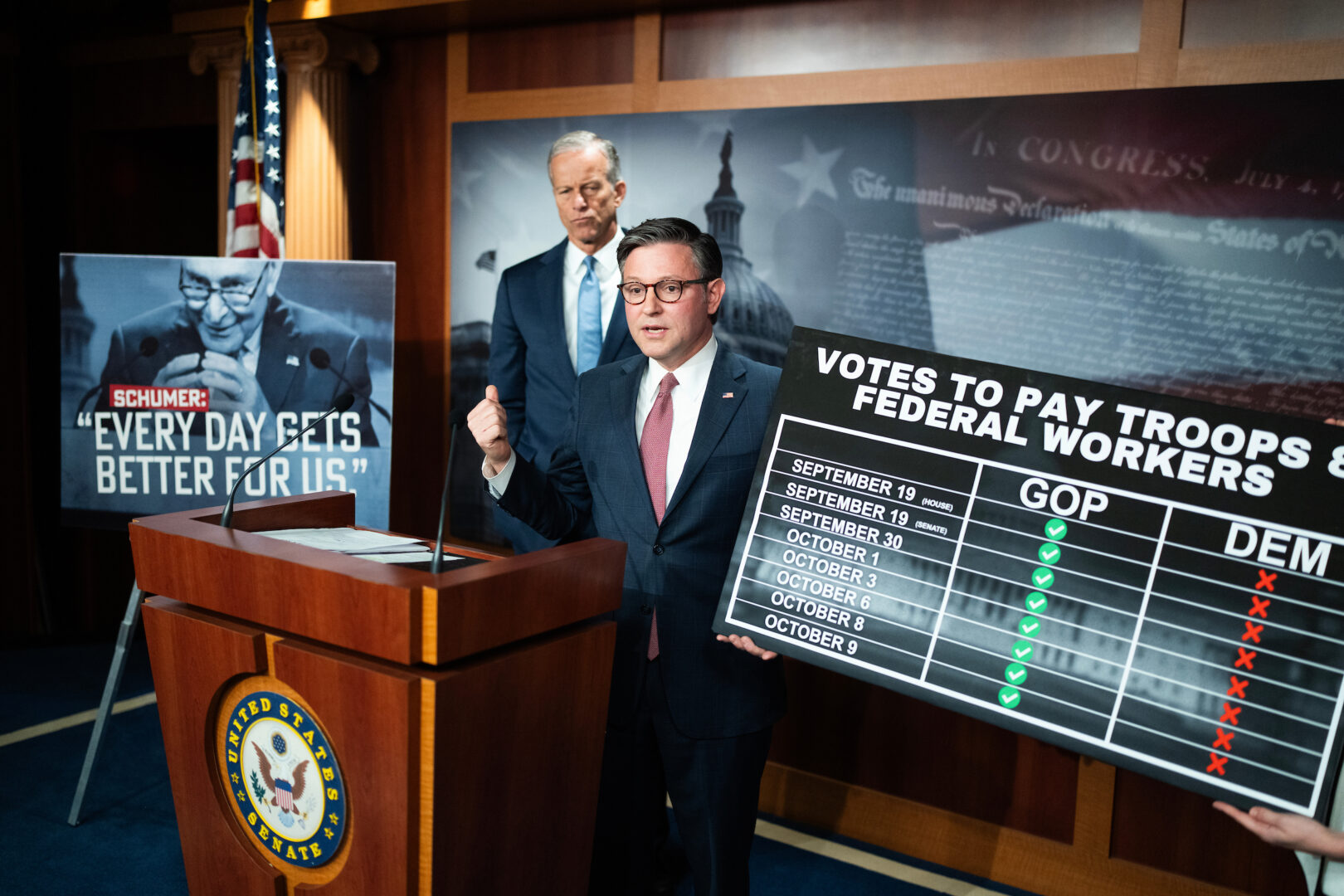 Speaker Mike Johnson holds up a chart during a news conference with Senate Majority Leader John Thune on the government shutdown in the Capitol on Friday.
