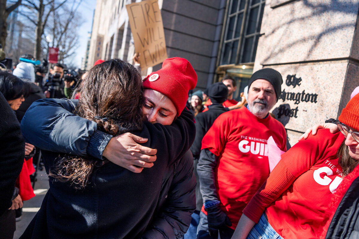 Marissa Lang, an enterprise reporter who was laid off by The Washington Post, hugs a supporter during the Save the Post rally outside the newspaper’s offices on Thursday after about 300 newsroom employees were fired the day before.