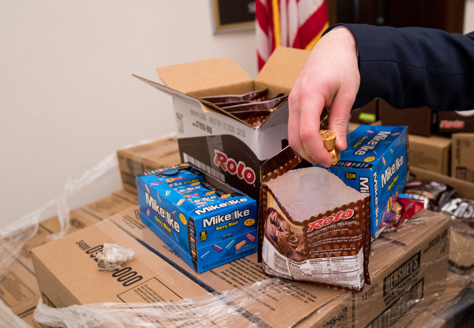 A reporter grabs a handful of candy from a pallet outside the office of then-Sen. Patrick J. Toomey, R-Pa., on Jan. 24, 2020. The candy was sent to resupply the candy desk on the Senate floor during the 2020 impeachment trial. 