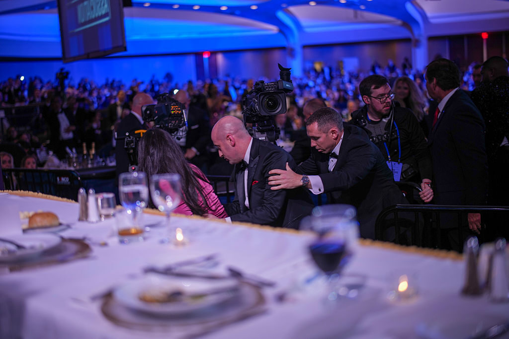 Katie Miller and Stephen Miller are escorted out after an incident at the annual White House Correspondents' Association Dinner on Saturday in Washington, DC. 