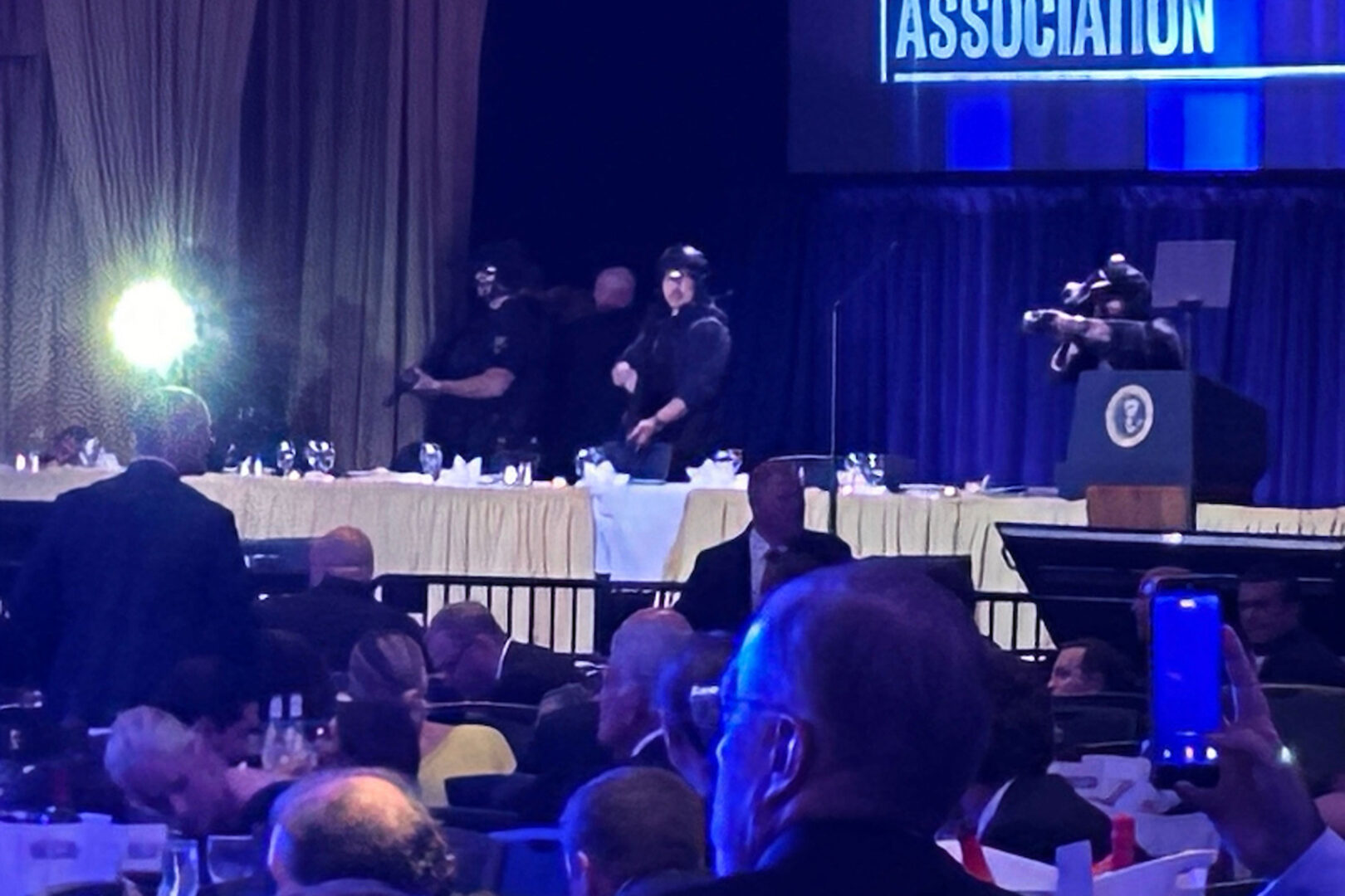 Guests and armed security agents are seen during the White House Correspondents’ Association dinner after a gunman tried to enter the ballroom of the Washington Hilton on Saturday.