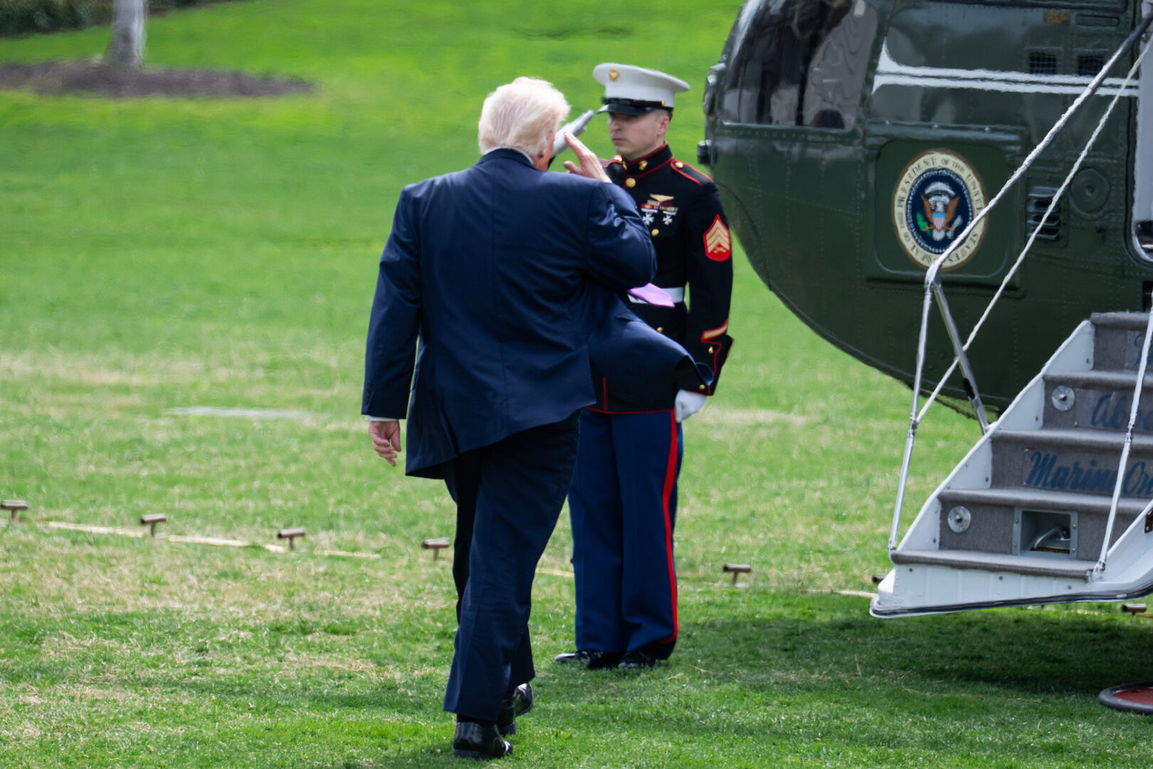 President Donald Trump salutes a Marine on the South Lawn of the White House before boarding Marine One on March 11.